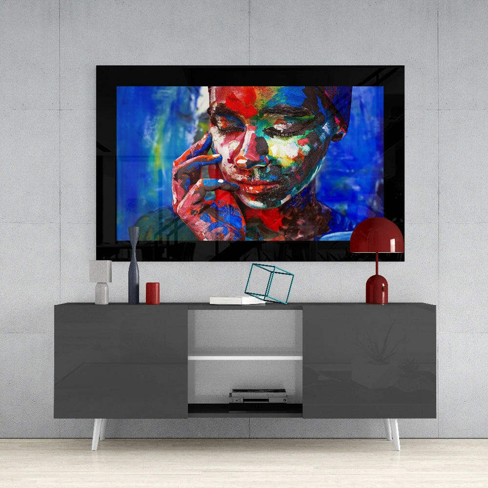Modern living room setup with mounted TV displaying colorful portrait artwork above gray media console with decorative items.