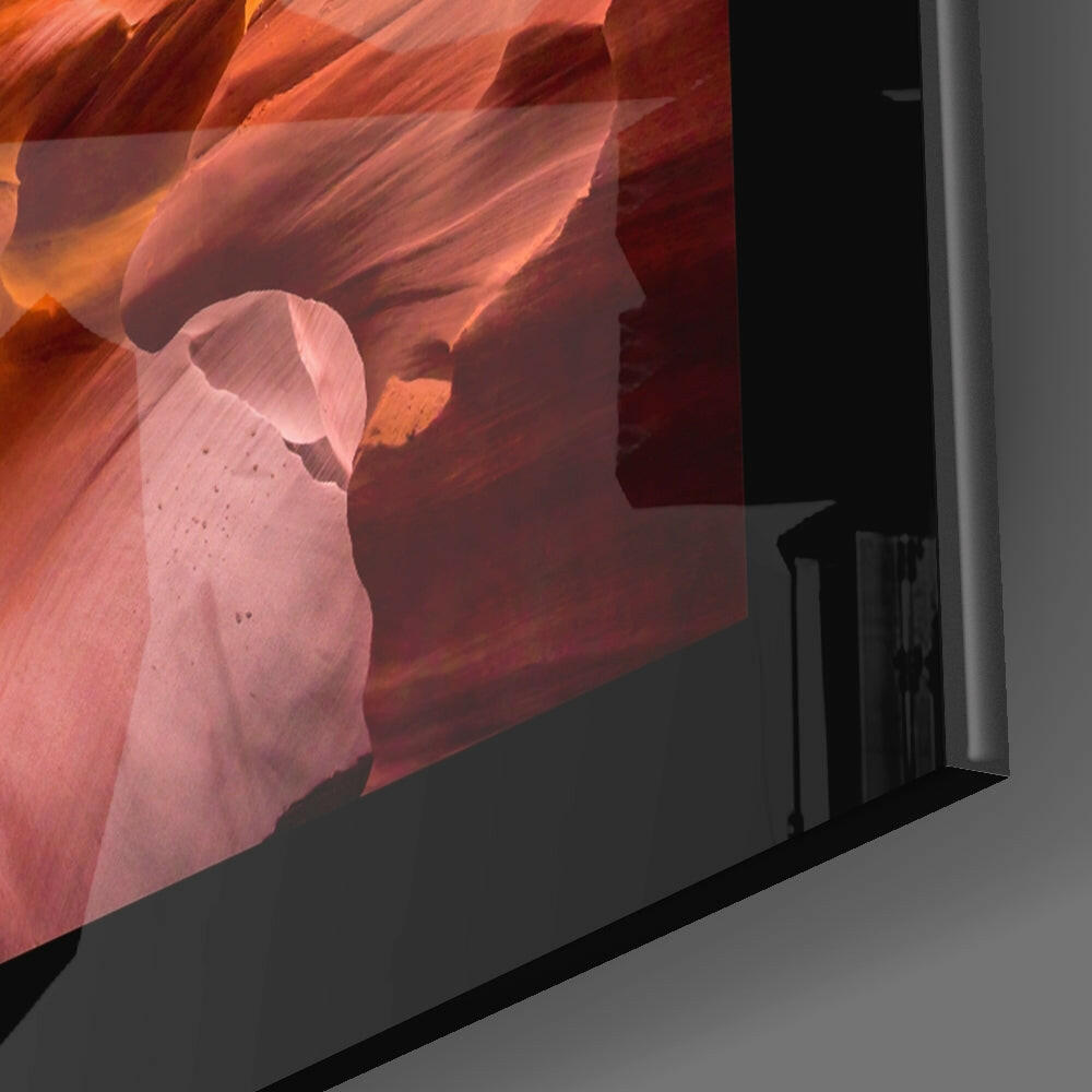 Angled side view of glass wall art displaying warm orange and red canyon formations with translucent glass panel edge visible.