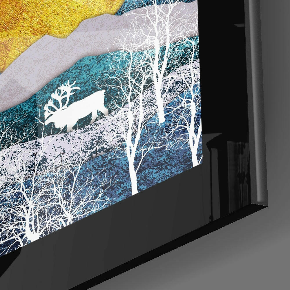 Angled side view of framed glass wall art featuring white silhouetted trees against layered blue and golden textured landscape.