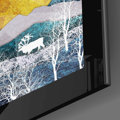 Angled side view of framed glass wall art featuring white silhouetted trees against layered blue and golden textured landscape.