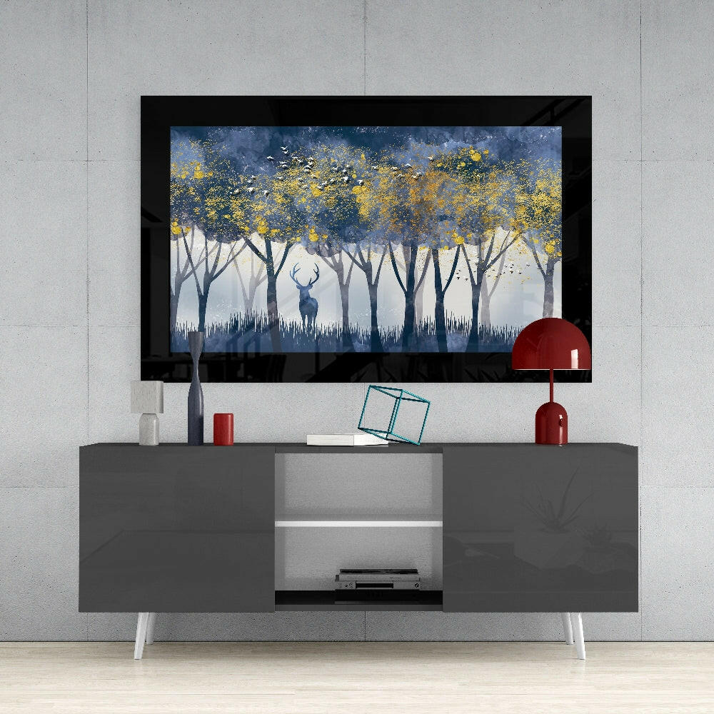 Silent Forest Glass Wall Art mounted above a gray media console displaying a misty forest scene with golden foliage and a blue deer silhouette.