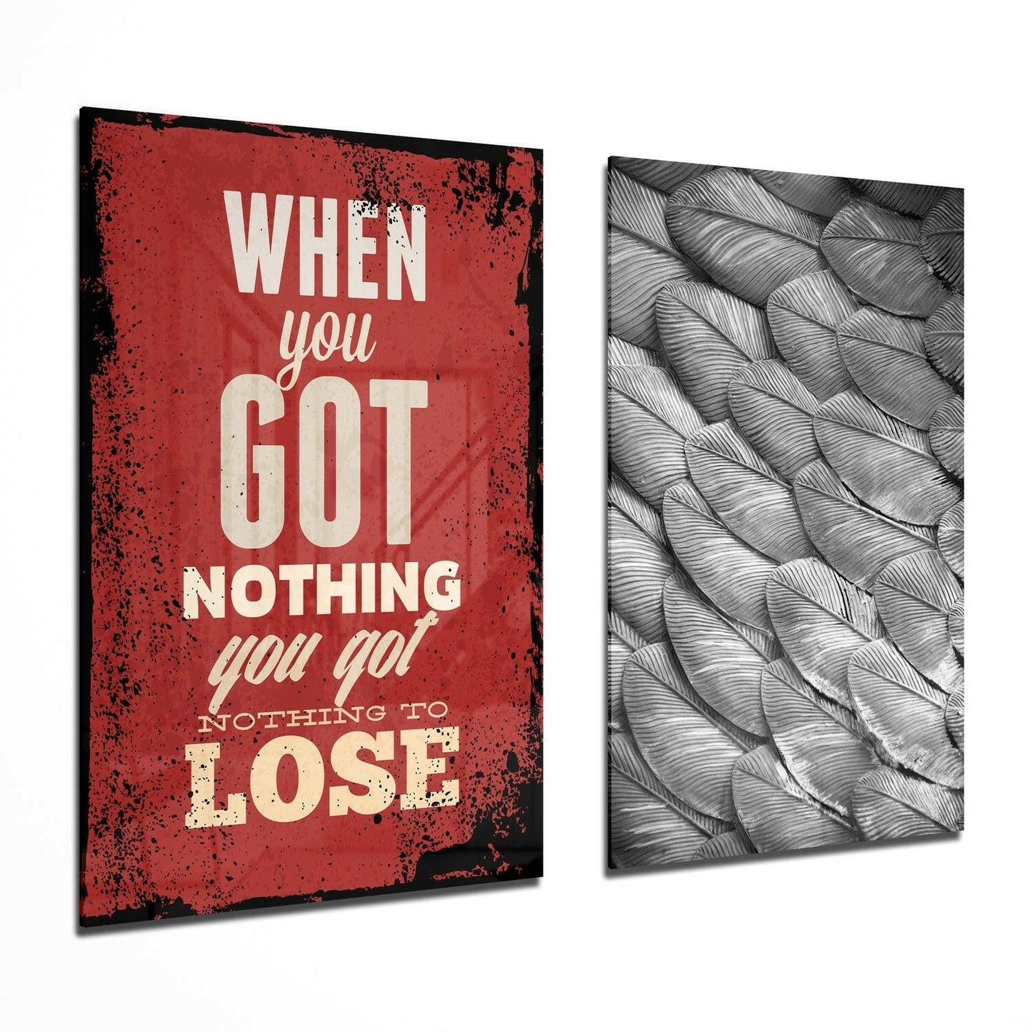 Two angled glass wall panels displayed side-by-side: red distressed panel with cream text reading "When you got nothing you go! nothing to lose" and gray textured feather pattern panel.