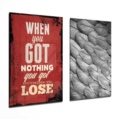 Two angled glass wall panels displayed side-by-side: red distressed panel with cream text reading "When you got nothing you go! nothing to lose" and gray textured feather pattern panel.