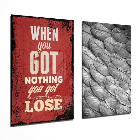 Two angled glass wall panels displayed side-by-side: red distressed panel with cream text reading "When you got nothing you go! nothing to lose" and gray textured feather pattern panel.
