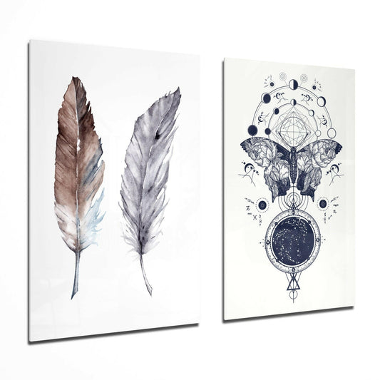 Two glass wall art panels displayed at an angle: left panel shows two watercolor feathers in brown and gray tones; right panel features an intricate celestial design with a butterfly, moon phases, constellation circle, and starfield.