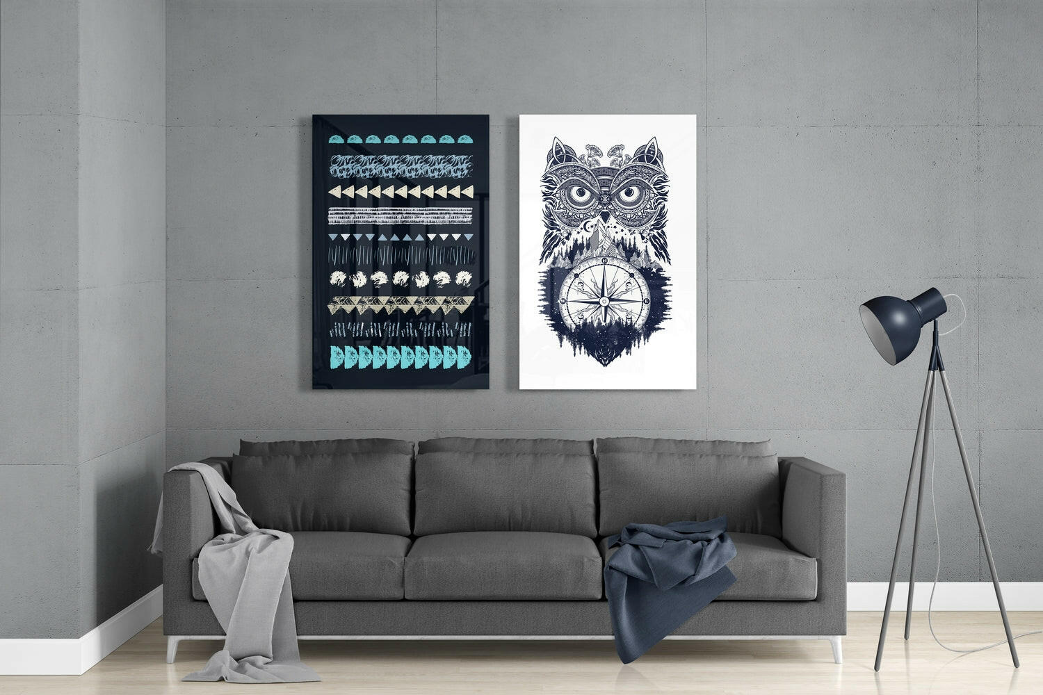 Modern living room with gray sofa displaying two framed glass wall artworks: dark geometric patterns and intricate owl with compass design.