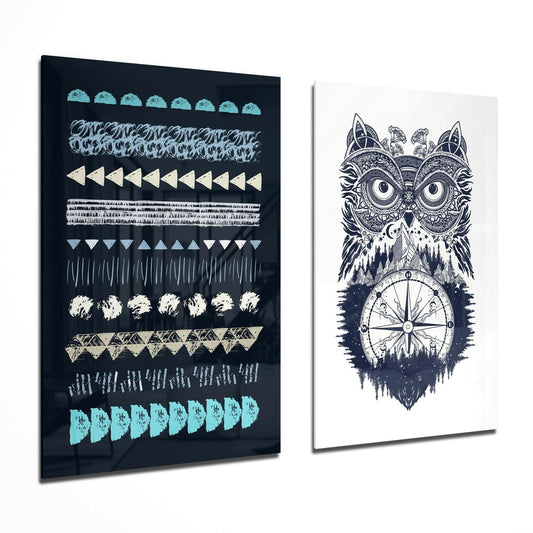Two glass wall art panels displayed at an angle: left panel with geometric patterns in turquoise, cream, and gray on black; right panel with intricate owl and compass design in navy and white.