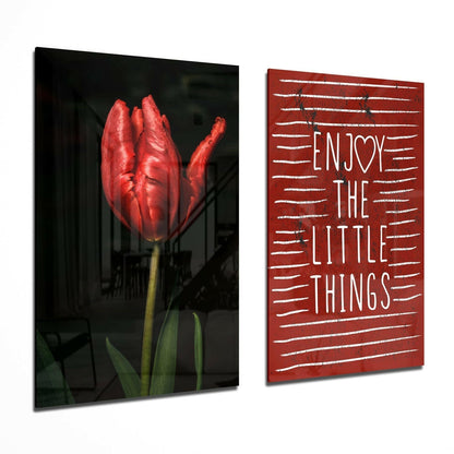 Two glass wall art panels displayed at an angle: left panel shows a red tulip on dark background; right panel displays "ENJOY THE LITTLE THINGS" text on red with white lines.