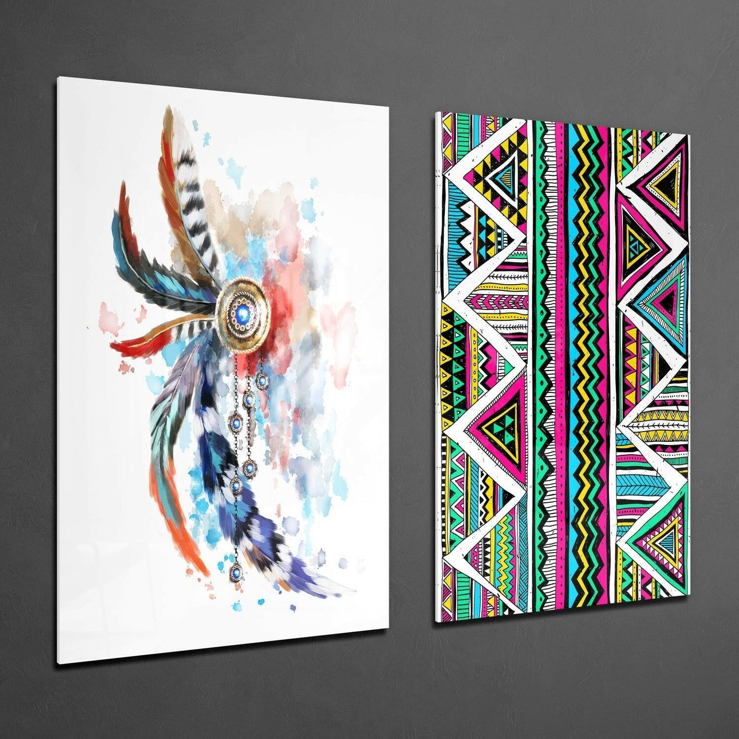 Two glass wall art panels displayed at an angle on gray wall: left panel shows watercolor feathered headdress in blue, red, and gold; right panel displays vibrant geometric tribal patterns in magenta, yellow, cyan, and black.