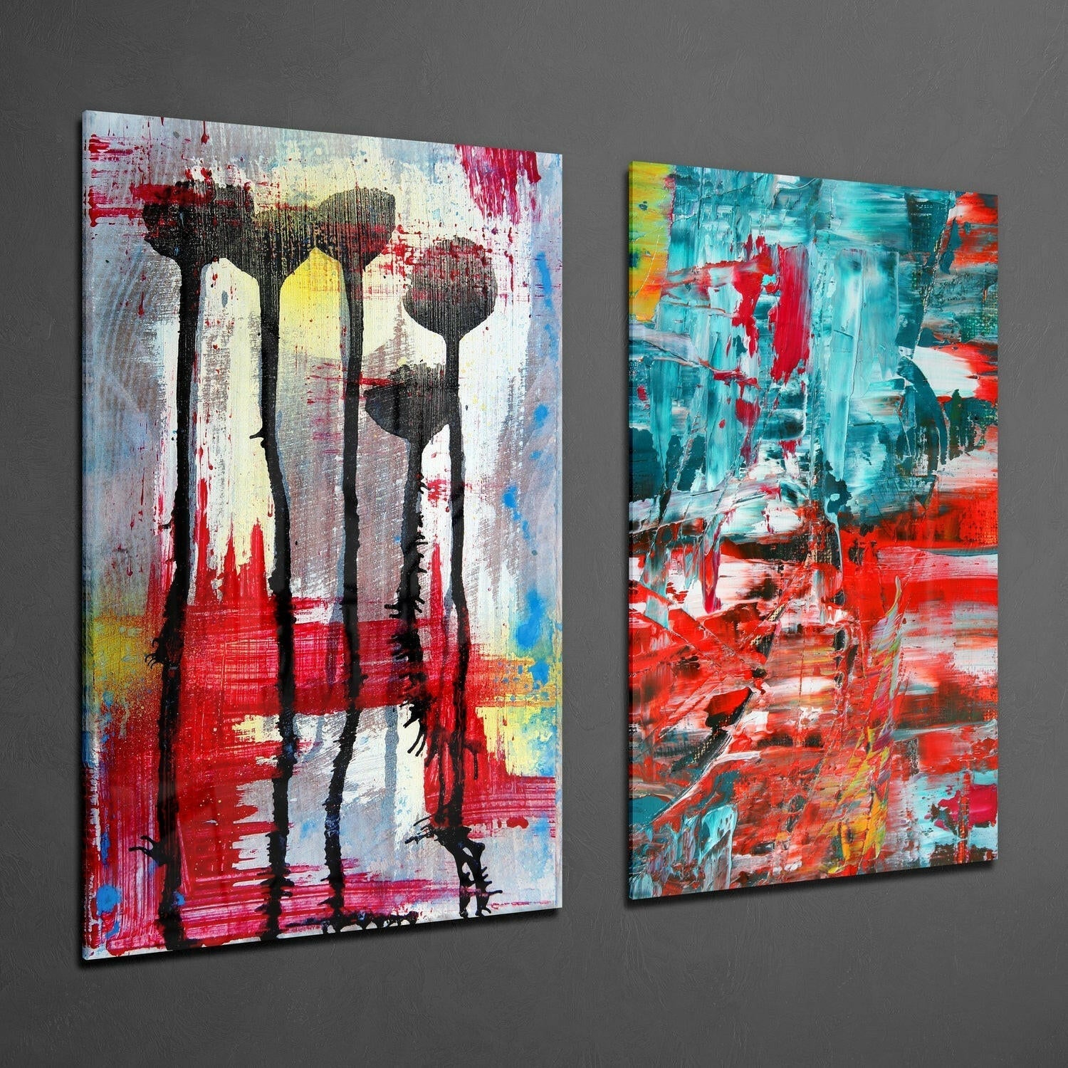 Two abstract glass wall art panels displayed against gray wall featuring stylized flowers with red, turquoise, yellow and black brushstrokes.