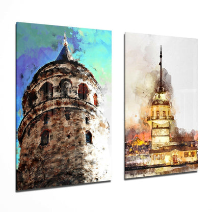 Two glass wall art panels displaying watercolor paintings of Istanbul's Galata Tower with vibrant blue and turquoise background, and Maiden's Tower illuminated in warm golden tones at dusk.