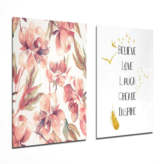 Two glass wall art panels displayed at an angle: left panel features watercolor pink orchids; right panel shows inspirational text "Believe Love Laugh Create Inspire" with gold birds and accents.