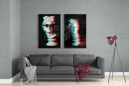 Modern living room with gray sofa displaying two framed glass wall artworks featuring cyan and red glitch-effect classical busts above.