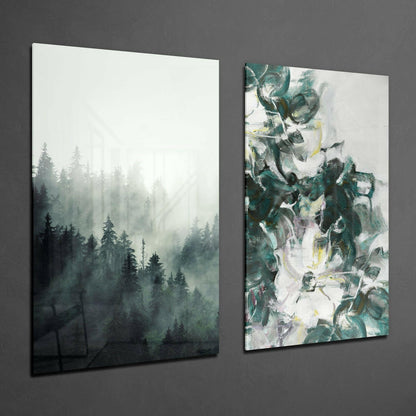 Two framed glass wall panels mounted on gray wall: left panel shows misty forest with evergreen trees, right panel displays abstract green and white brushstroke design.