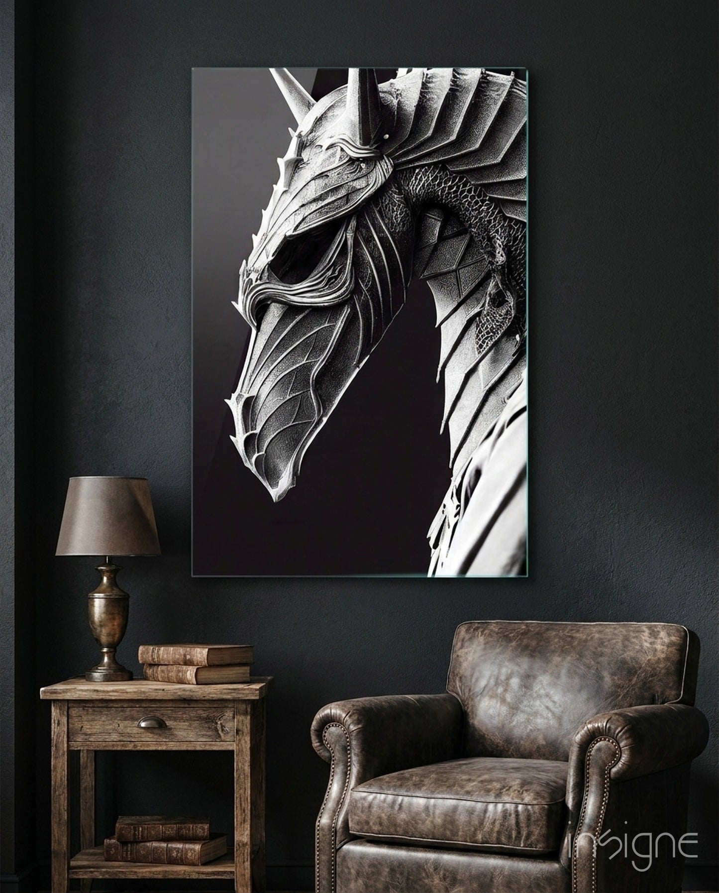 Monochromatic glass art depicting a detailed dragon head in profile against black background, displayed above leather armchair in dark interior setting.