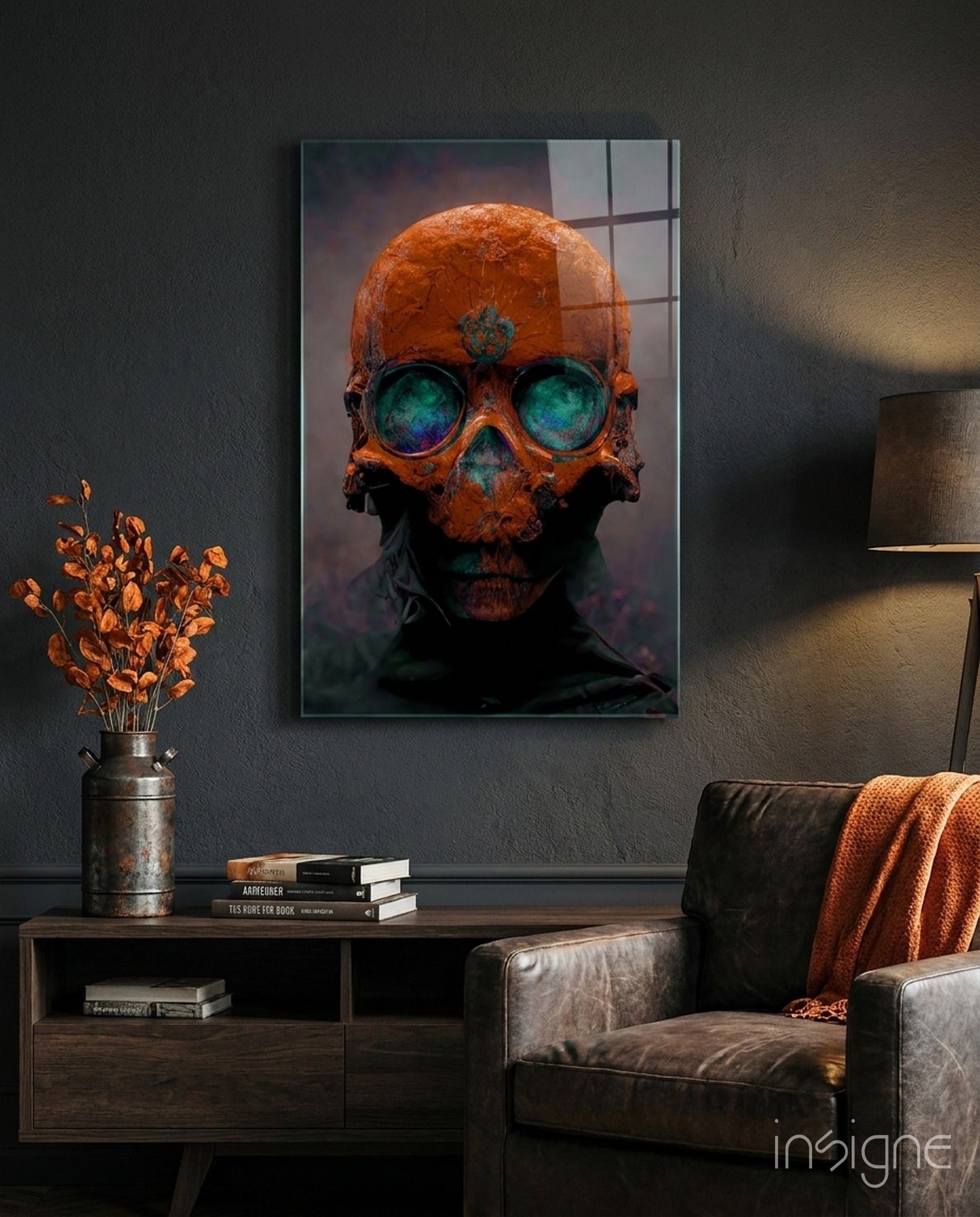 Orange skull with glowing turquoise eyes mounted on dark wall above wooden console table with books and dried flowers.