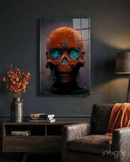 Orange skull with glowing turquoise eyes mounted on dark wall above wooden console table with books and dried flowers.