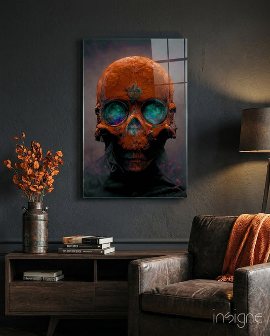 Orange skull with glowing turquoise eyes mounted on dark wall above wooden console table with books and dried flowers.