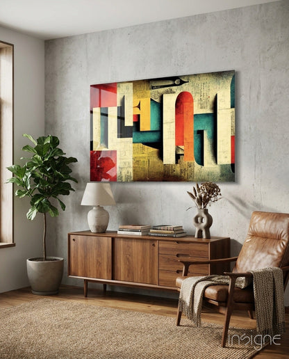 Colorful abstract geometric glass art with red, yellow, teal, and cream blocks displayed above wooden mid-century credenza in modern living room.