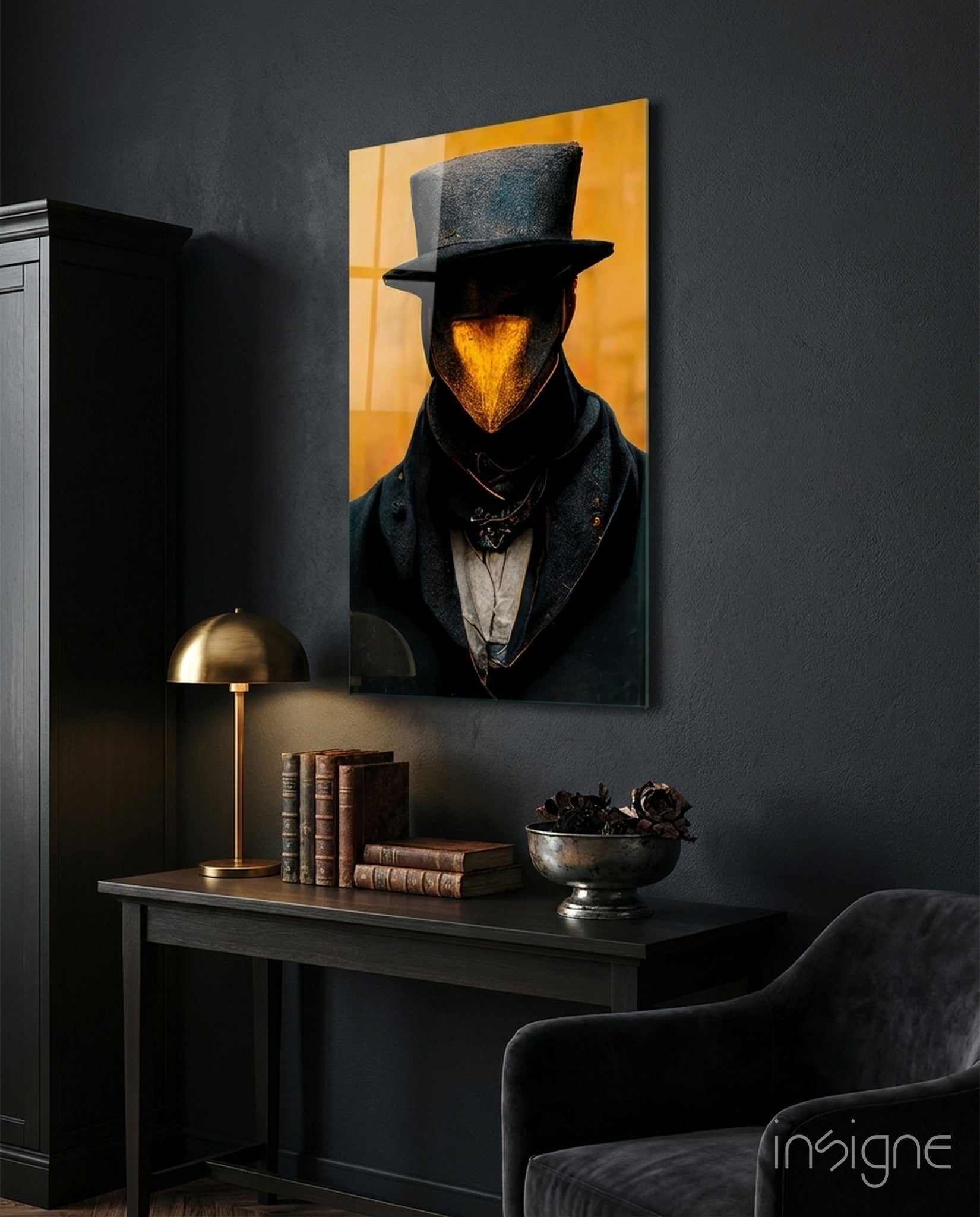 Mr. Beak glass art displayed on dark wall above desk with brass lamp, vintage books, and metal bowl, golden background glowing behind figure wearing top hat.
