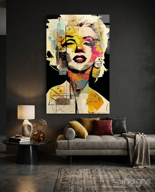 Pop art glass wall art depicting a blonde woman's face in vibrant yellow, pink, and blue tones displayed above a gray sofa in a modern living room.