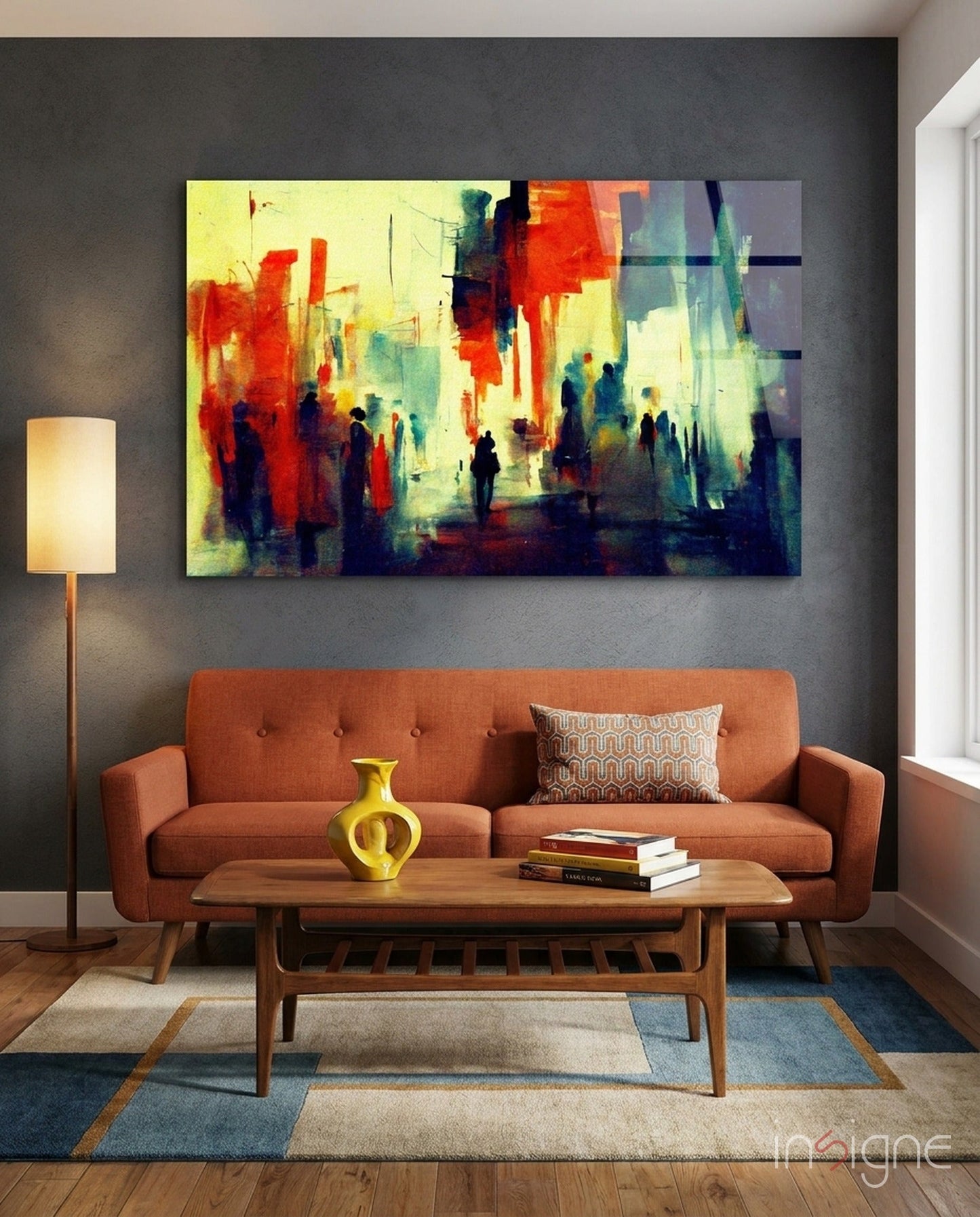 Modern living room with orange sofa, wooden table, and colorful abstract cityscape glass wall art above.