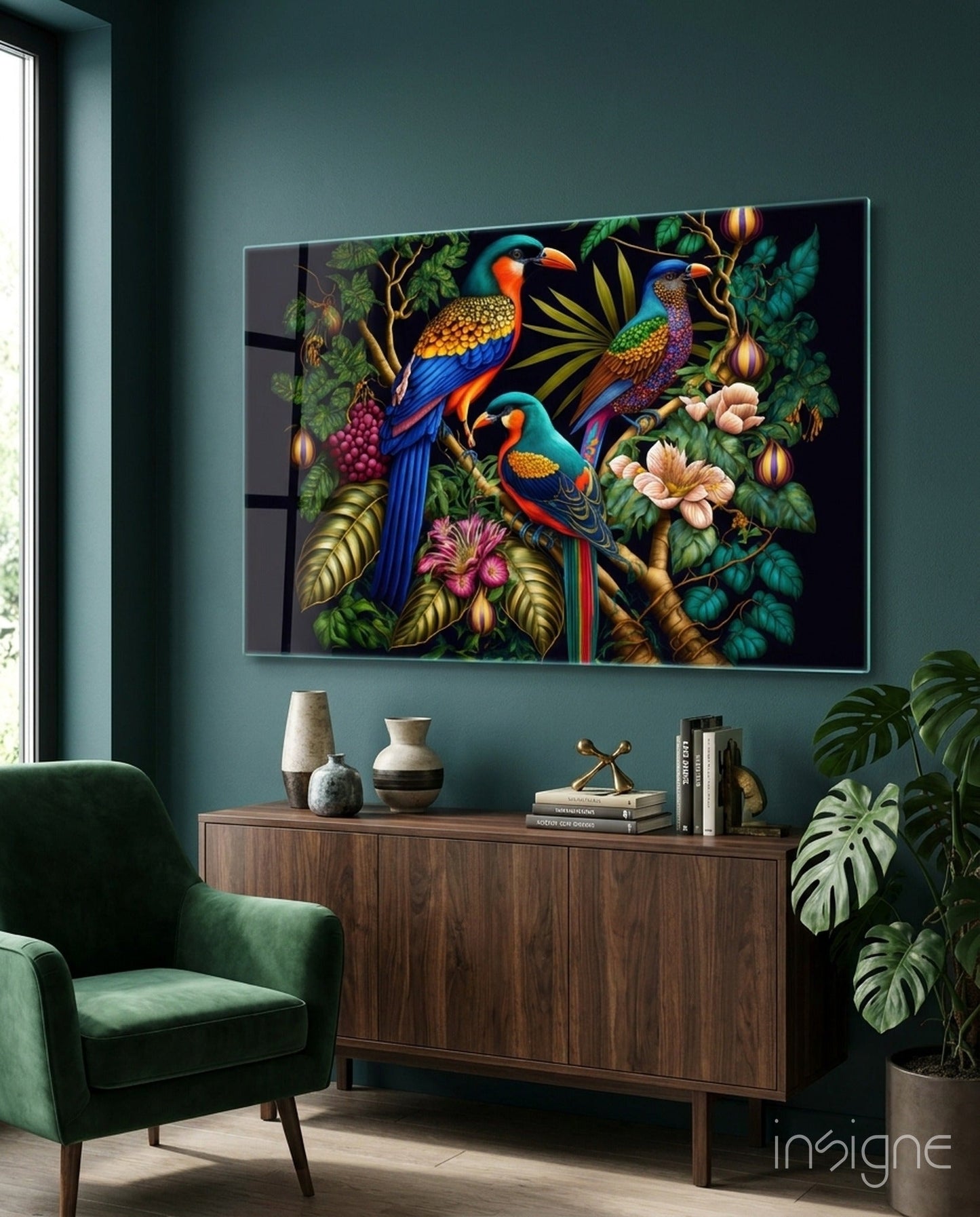 Tropical Birds Glass Wall Art displayed above a wooden console in a teal room with green chair and potted plants nearby.