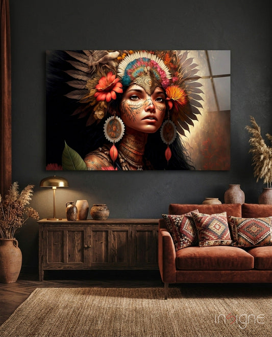 Glass wall art depicting indigenous woman with feathered headdress and facial paint displayed above wooden cabinet in styled living room setting.