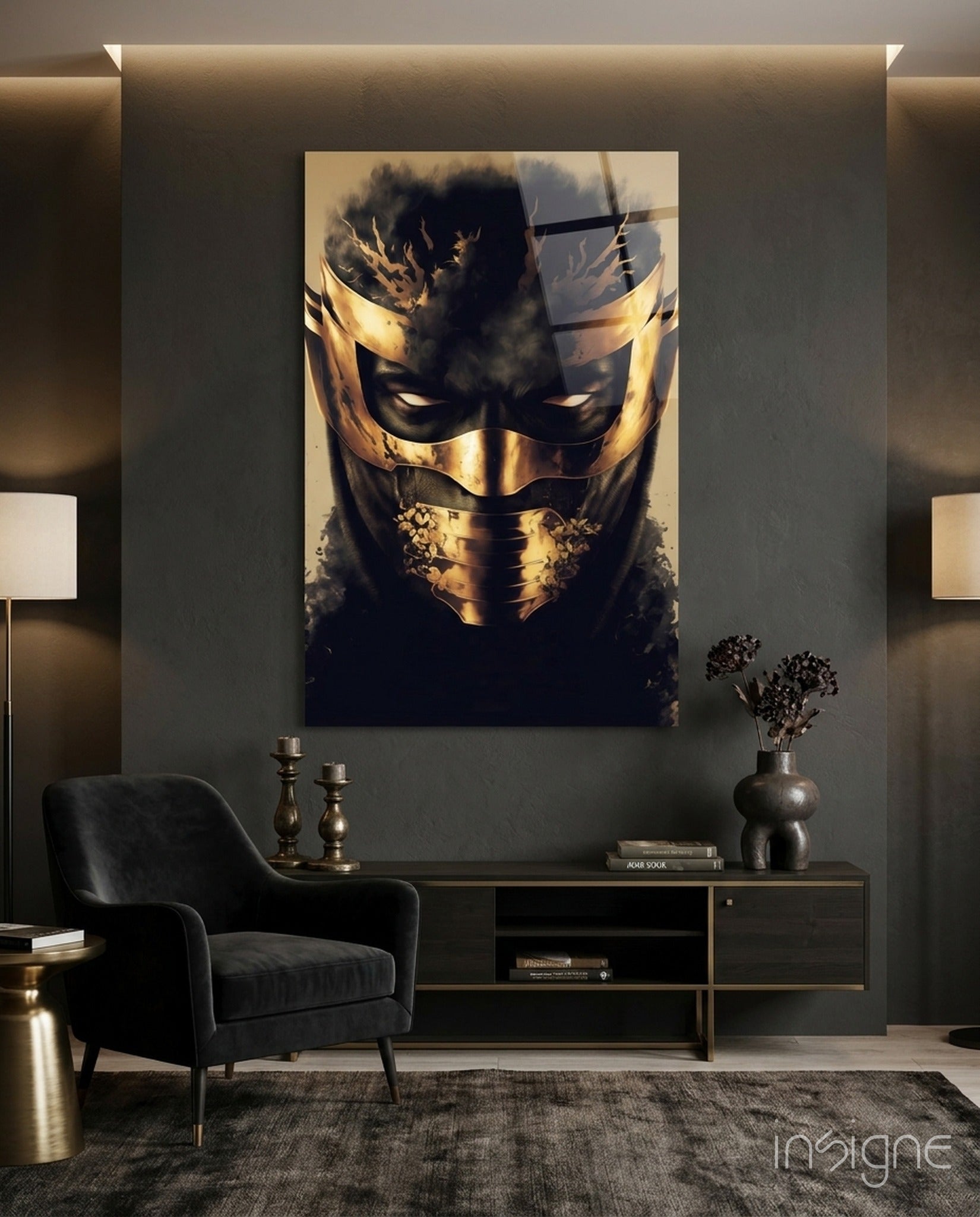 Gold and black masked face glass art displayed on grey wall above black console table in modern interior setting.
