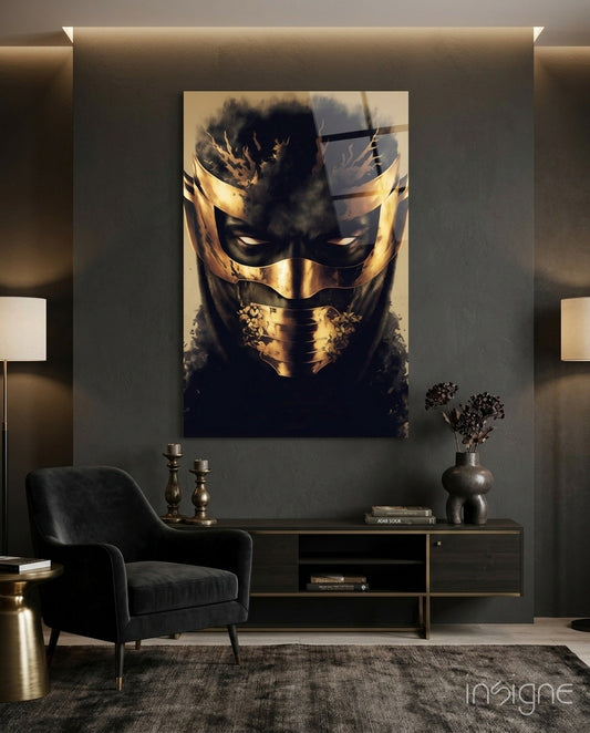 Gold and black masked face glass art displayed on grey wall above black console table in modern interior setting.