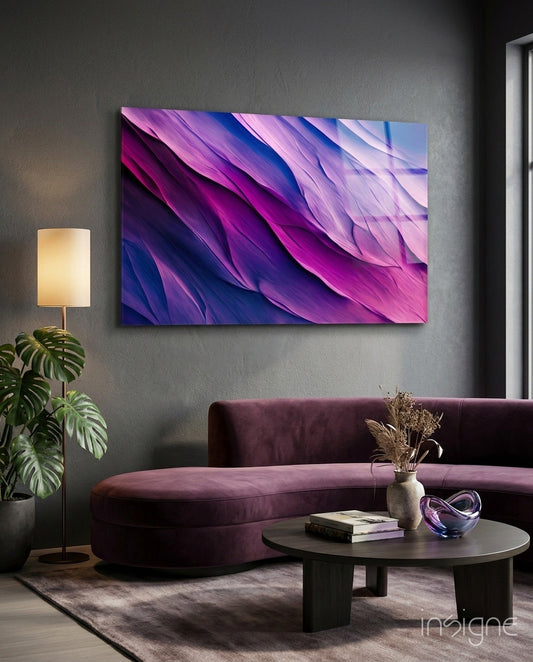 Purple Dance glass wall art displayed above a curved burgundy sofa in a modern living room setting.