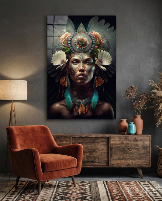 Glass wall art depicting a woman with ornate facial tattoos and a elaborate floral headdress displayed above a wooden dresser in a styled interior.