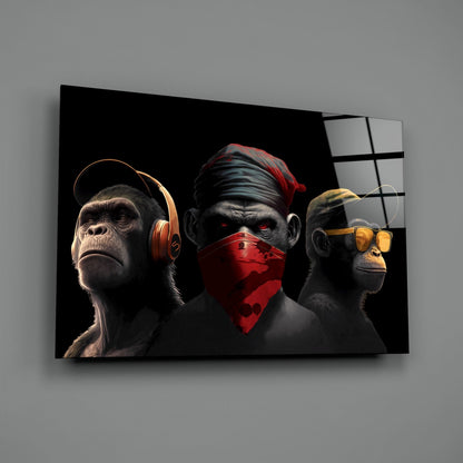 Three stylized monkeys wearing headphones, a red bandana, and sunglasses displayed on black glass wall art against gray background.