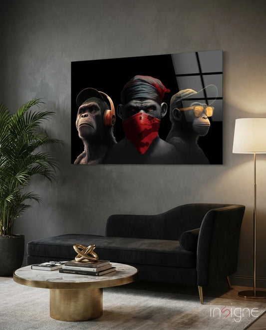 Modern living room with black sofa displaying glass wall art of three stylized monkeys wearing headphones, mask, and sunglasses against dark background.