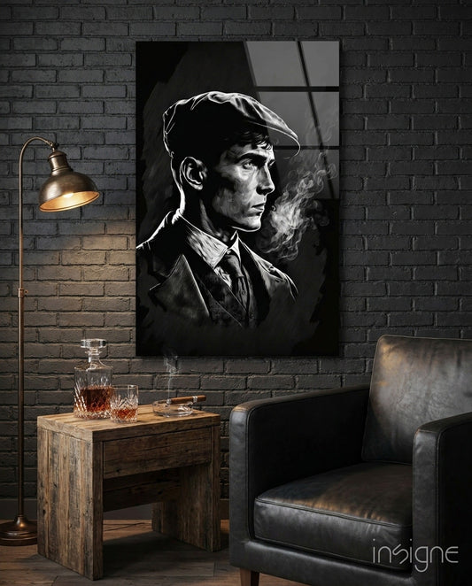 Black and white portrait of a man in flat cap and coat smoking, displayed on brick wall above wooden table with whiskey decanter and leather chair.