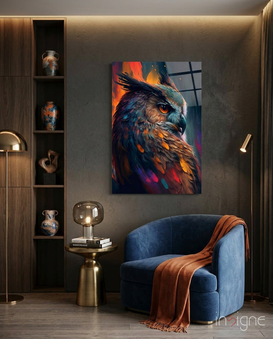 Teal and orange owl glass wall art displayed in modern interior above blue chair with brass side table and wooden shelving.