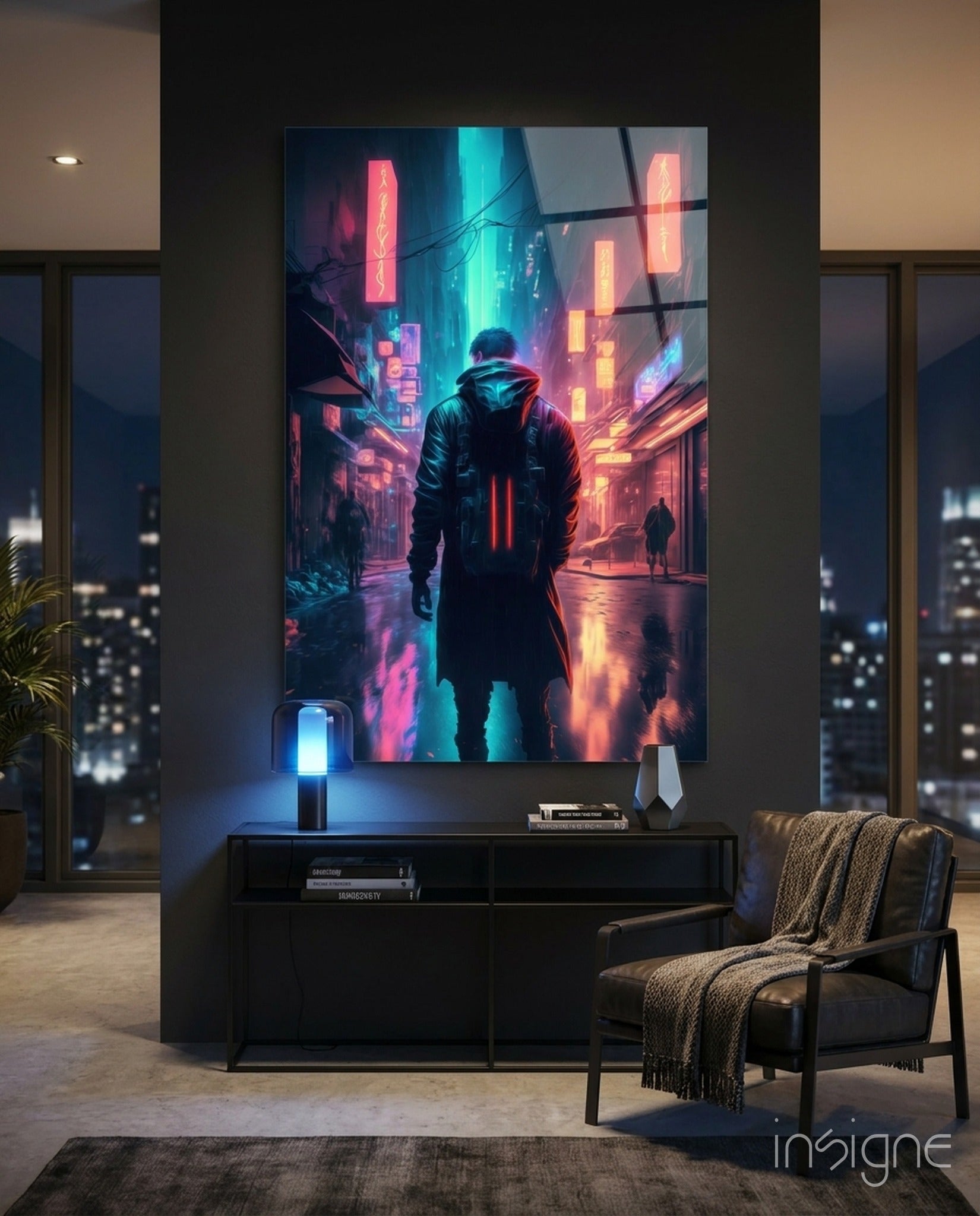 Cyberpunk glass wall art displaying neon-lit street scene with hooded figure in pink and cyan tones, mounted above black cabinet in modern apartment interior.