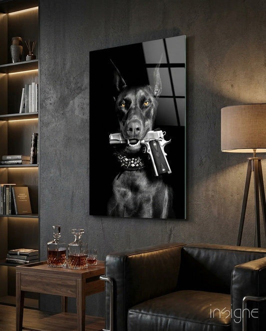 Black and white glass wall art depicting a stern doberman with golden eyes holding a silver pistol in its mouth, displayed in a modern study room.
