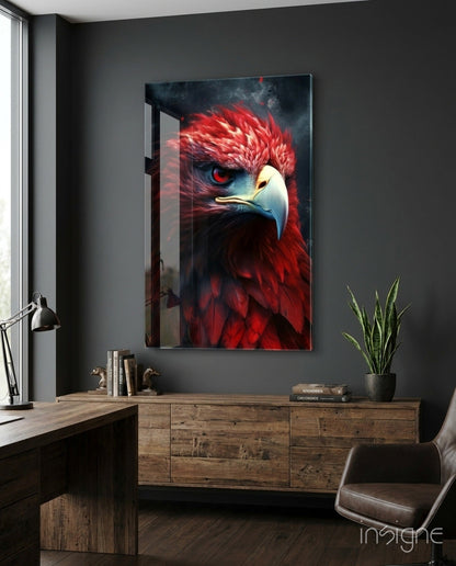 Red eagle glass wall art with crimson feathers and red eyes displayed above wooden dresser in modern office setting.