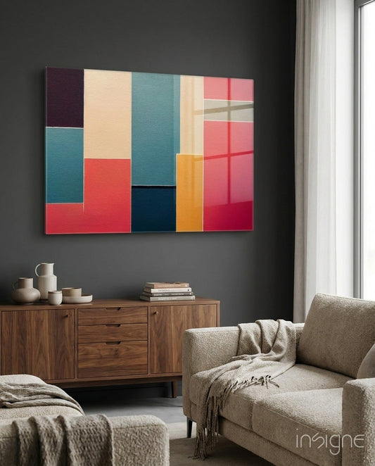 Colorful geometric glass wall art with red, teal, cream, orange, and navy rectangles displayed above wooden credenza in modern living room.