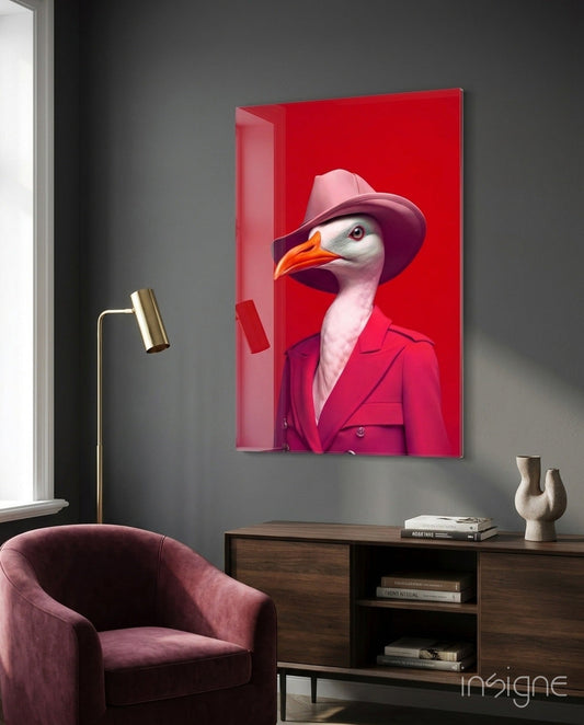 Glass wall art displaying a stylized seagull in hot pink suit and cowboy hat against red background, hung in modern gray room above wooden console table.