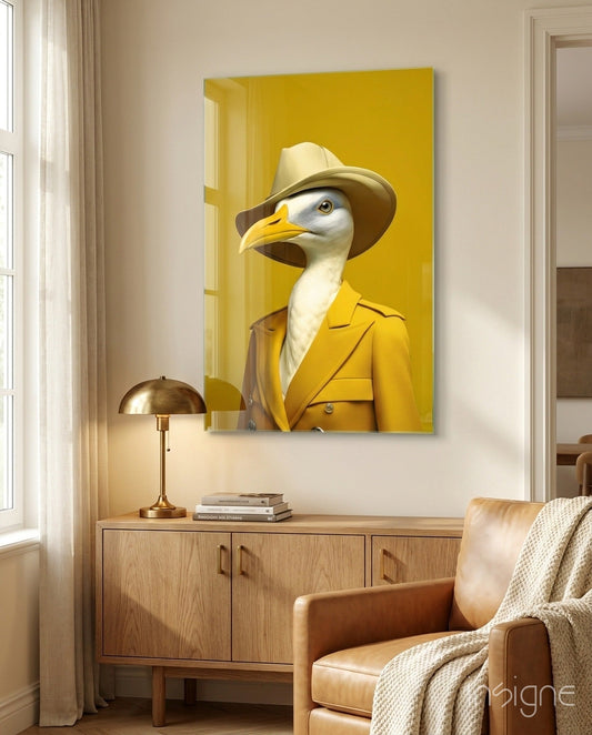 Mustard yellow glass wall art depicting an anthropomorphic seagull wearing a cowboy hat and yellow blazer, displayed above a wooden cabinet in a modern living room.