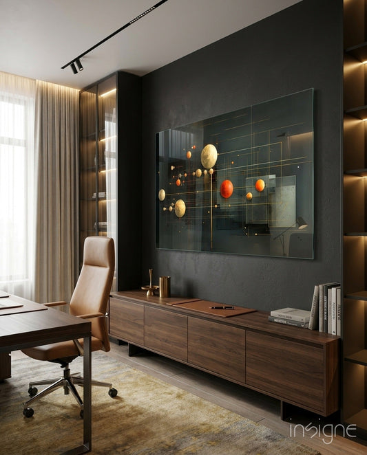 Modern office featuring planets glass wall art with golden and orange spheres displayed above wooden cabinet against dark charcoal wall.