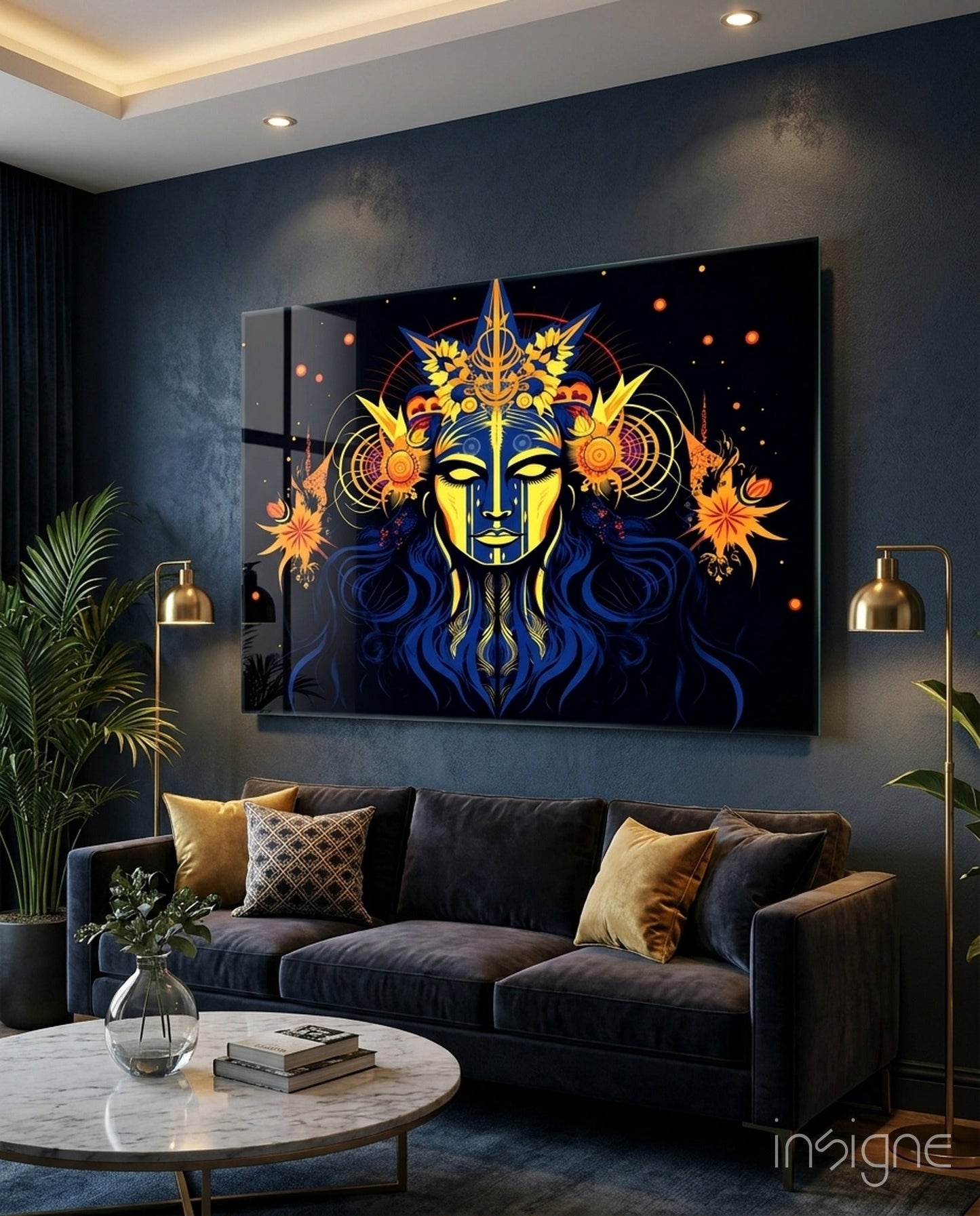 Illuminated glass wall art depicting a gold and blue mystical face with ornate celestial designs displayed above a dark sofa in a modern living room.