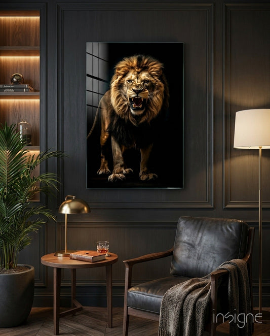 Framed lion portrait with golden mane roaring against black background, displayed on dark paneled wall above wooden side table in modern interior setting.