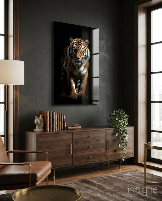 Tiger glass wall art displayed above a wooden dresser in a modern living room with dark walls and natural light from windows.