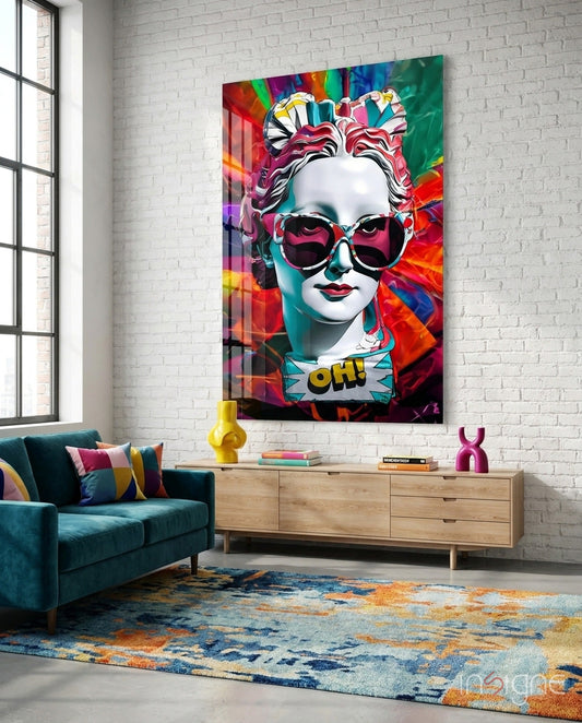 Colorful pop art portrait with heart-shaped sunglasses and "OH!" text displayed on white brick wall above teal sofa and wooden console.