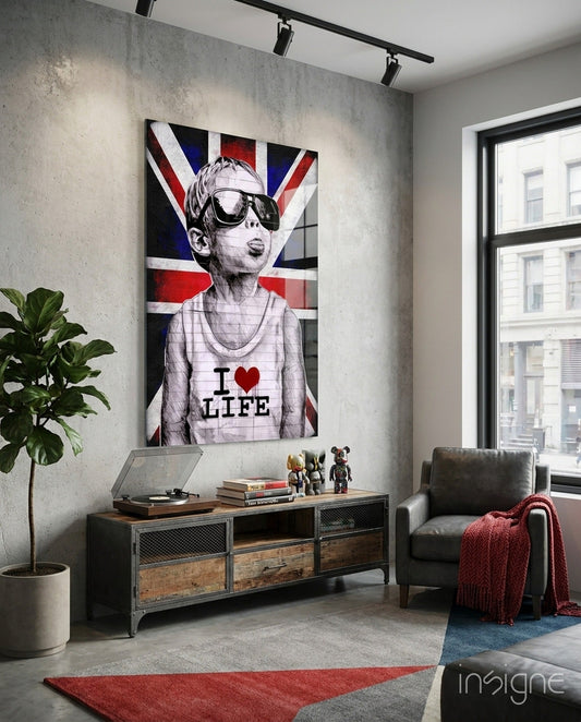 Union Jack Sunglasses Boy glass wall art displayed above industrial console table in modern living room with concrete walls and leather chair.