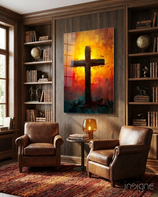 Fiery orange and teal sunburst cross glass art displayed on wood-paneled wall above leather chairs in library study.