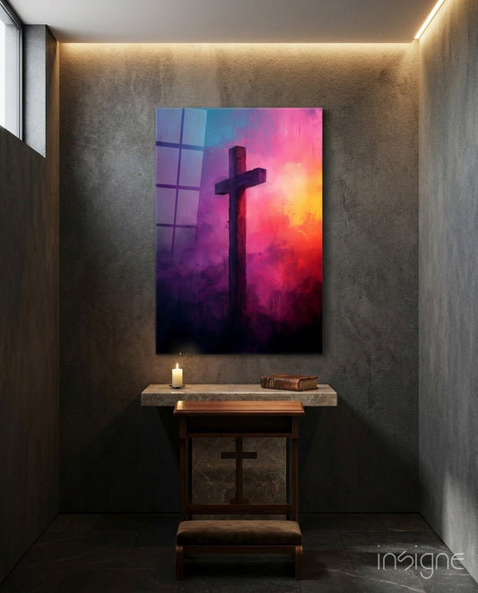 Magenta and purple cloud cross glass art hanging above a wooden altar in a concrete chapel with candlelight and a book.